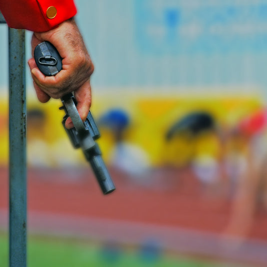Track race holding blank firing gun in hand